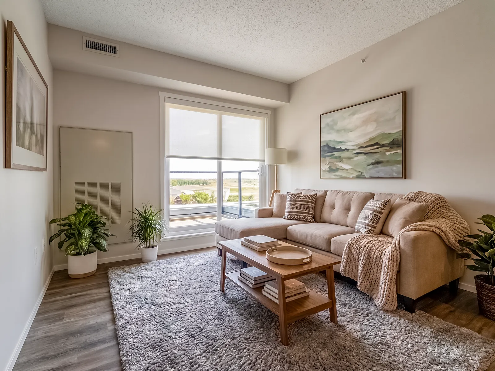 Living room in an Emerald Place suite with a cordless light-filtering roller shade