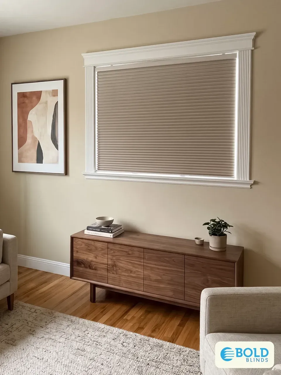 A closed honeycomb shade covering a large living room window above a wood sideboard