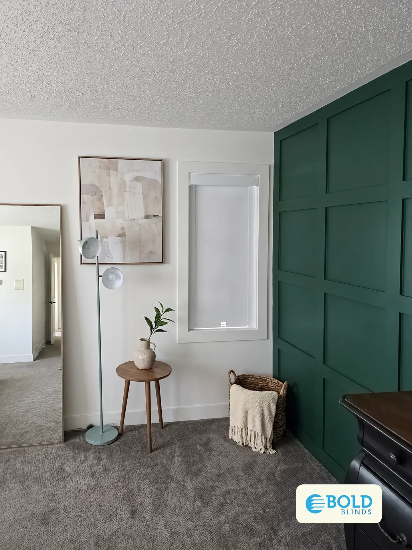 Bedroom with a green panelled feature wall and a white roller shade on the window
