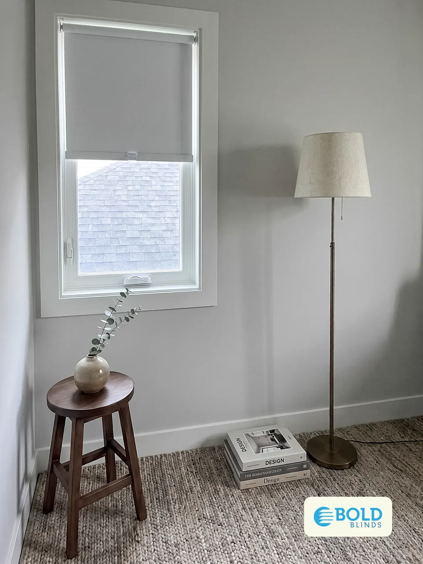 White roller shade half lowered on a bedroom window