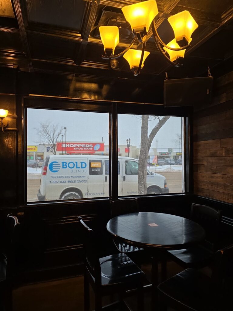 Edmonton restaurant dining room with custom made-to-measure window blinds controlling glare and creating cozy ambiance.